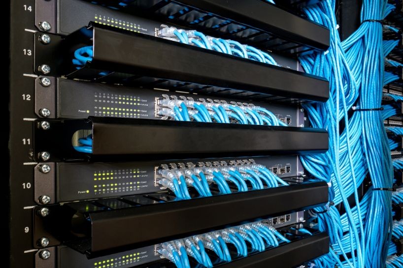 Structured cabling system with organized blue Ethernet cables connected to patch panels in a server rack – network installation setup in Oxnard, CA
